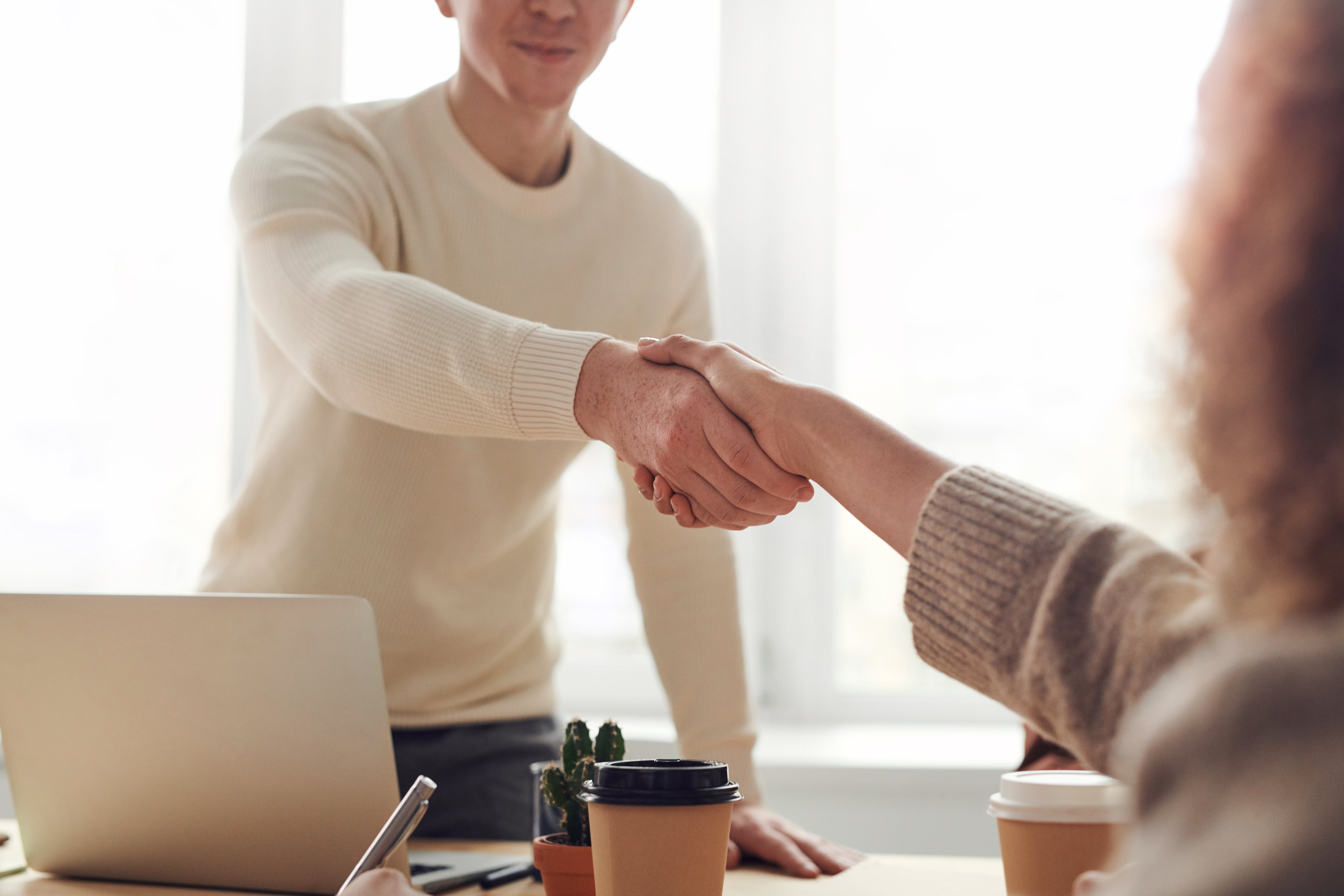 beige shaded image of a handshake